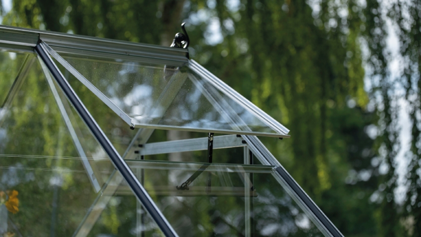 Close-up of Halls ICON 6 greenhouse roof vent in mill aluminium frame with 3mm horticultural glass panel open for ventilation