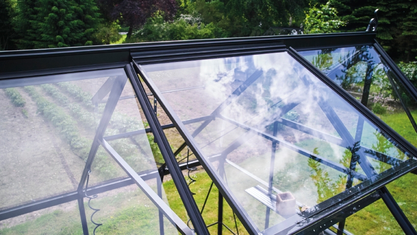 Close-up of Halls ICON 8 8x10 greenhouse roof vent, powder-coated black aluminium frame, and toughened glass panel open for ventilation