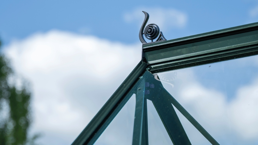 Close-up of roof cresting installed on the Halls ICON Gardenhouse 6 6x10, finished with toughened glass and a powder-coated green aluminium frame.