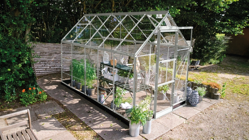 Halls ICON 6 6x10 greenhouse with mill aluminium frame and 3mm horticultural glass installed on patio with staging and plants inside
