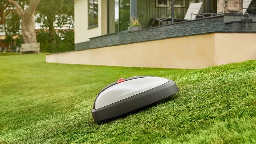 Honda Miimo HRM 310 robotic lawnmower mowing a sloped garden with automatic hillside navigation