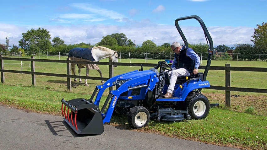 Iseki TXGS24 compact tractor with loader in use near paddock and horse enclosure