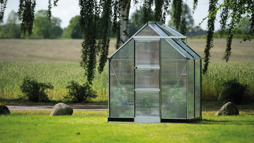 Wide-angled image of the Halls ICON 6 6×4 Greenhouse, with polycarbonate glazing and a mill aluminium frame.