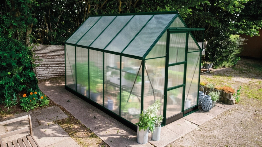 Wide-angled image of the Halls ICON 6 6x10 Greenhouse, with polycarbonate glazing and a powder-coated green aluminium frame.