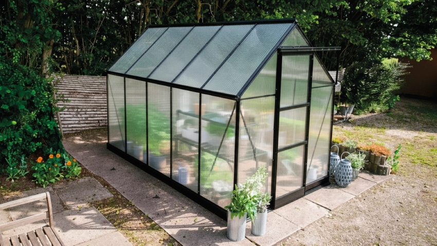 Wide-angled image of the Halls ICON 6 6x10 Greenhouse, with polycarbonate glazing and a powder-coated black aluminium frame.