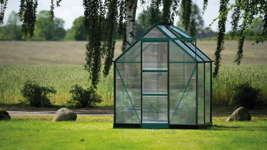 Wide-angled image of the Halls ICON 6 6x4 Greenhouse, with polycarbonate glazing and a powder-coated green aluminium frame.