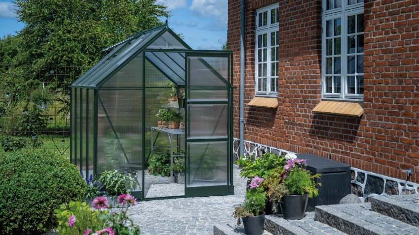 Wide-angled image of the Halls ICON 6 6x8 Greenhouse, with polycarbonate glazing and a powder-coated green aluminium frame.