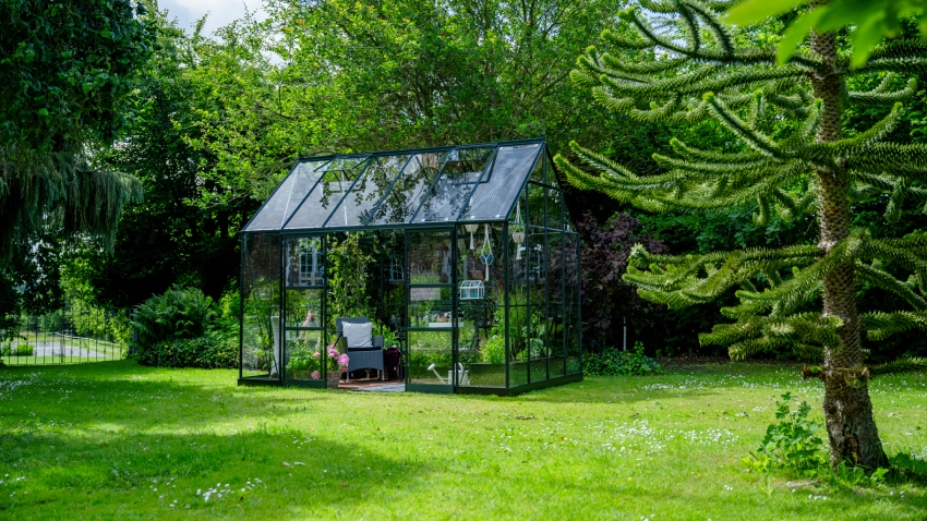 Wide-angled image of the Halls ICON Planthouse 8 8x12, with toughened glass and a powder-coated green aluminium frame.