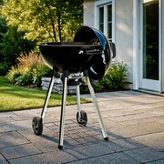 Broil King Crown Charcoal Kettle BBQ 47cm on patio with lid open, porcelain enamel charcoal grill ready for outdoor cooking