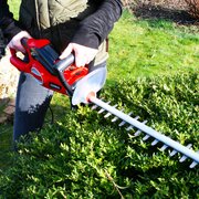 Lifestyle image of the HT550E Hedgetrimmer being used to trim a hedge
