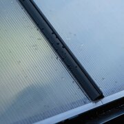 Detailed side profile of polycarbonate greenhouse capping on a Halls ICON 6, showing how panels are sealed and supported within the frame.