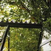 Halls ICON 6 greenhouse roof cresting HR01958 fitted along the full ridge of a 6x10 greenhouse, showing the decorative Victorian-style design against a garden backdrop.