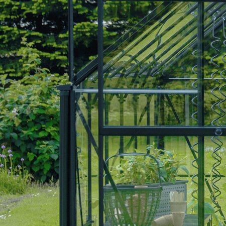 Halls Icon downpipe kit installed on a Halls ICON greenhouse, directing rainwater away from the frame.