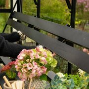 Person folding down the Halls modular folding shelving HR01933 inside an ICON 8 8x14 greenhouse, showing the adjustable, space-saving shelf design.
