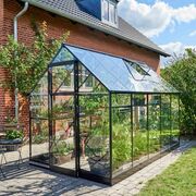 Front view of the Halls QUBE 610 6x10 greenhouse with black frame and toughened glass, showing sliding door access and interior plant benches.