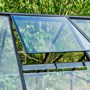 Close-up of the roof vent window on the Halls QUBE 610 6x10 greenhouse in black with toughened glass, showing automatic ventilation for temperature control.