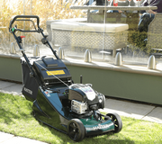 Hayter Harrier 48 Autodrive BBC VS self-propelled petrol lawnmower cutting a domestic lawn with rear roller for a striped finish