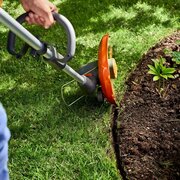 Husqvarna 110iL FLXi battery grass trimmer in edging mode trimming lawn border with support wheel