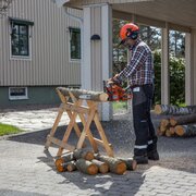 Husqvarna 120 Mark II petrol chainsaw with 14 inch bar cutting timber log outdoors