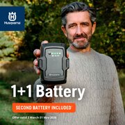 Man holding a Husqvarna BLi30 battery outdoors with text “1+1 Battery – Second Battery Included”. Offer valid 2 March to 31 May 2026. Applies to this Husqvarna kit product and includes one extra battery.