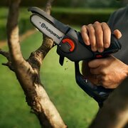 Husqvarna Aspire P5-P4A cordless pruner cutting tree branch, compact 18V battery pruning saw in garden use