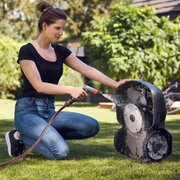 Husqvarna 305 automower being cleaned in a garden environment