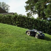 Husqvarna Automower 435X AWD NERA mowing a steep residential lawn demonstrating all-wheel drive capability