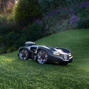 Husqvarna Automower 435X AWD NERA robotic mower cutting grass on a slope in a landscaped garden