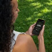 Woman controlling her automower via the Connect app, connected to her automower Connect Kit