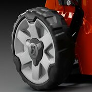 Close-up of aluminium wheel with rubber tyre on Husqvarna LC 551SP Pro 51cm self-propelled petrol lawn mower.