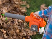 Close-up of the Husqvarna Toy Leaf Blower 586498001 being used to blow leaves during outdoor play