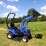 Iseki TXGS24 compact diesel tractor with front loader raised in open grass field