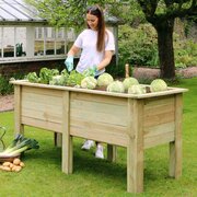 Deep Root Planter 1.8m with a woman planting vegetables in it