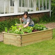 Large Sleeper Raised Bed with woman wokring on her flowers enjoying the sun